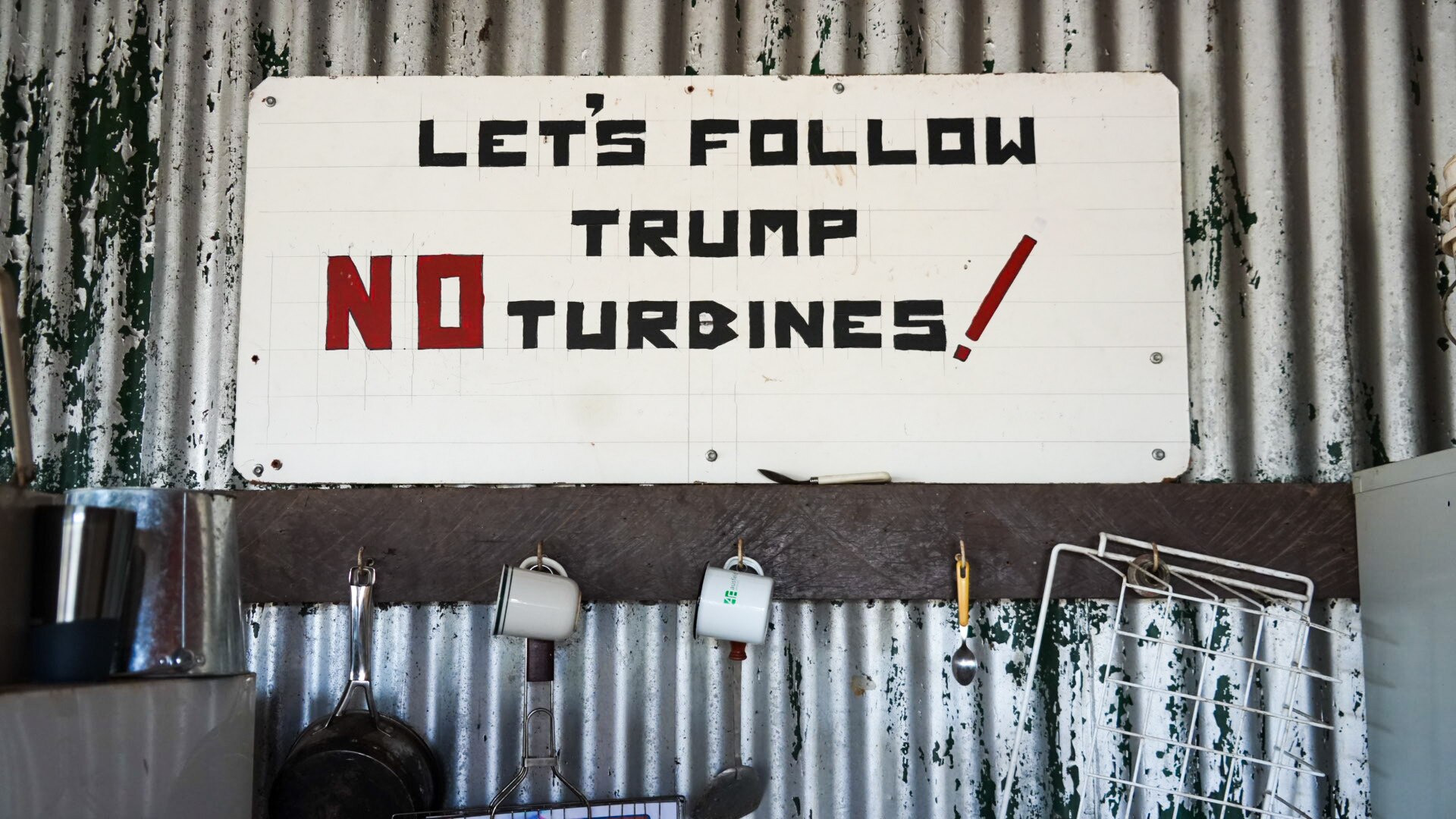 A sign opposing wind turbines in the kitchenette of the Mount Fox campground, reading lets follow Trump no turbines.