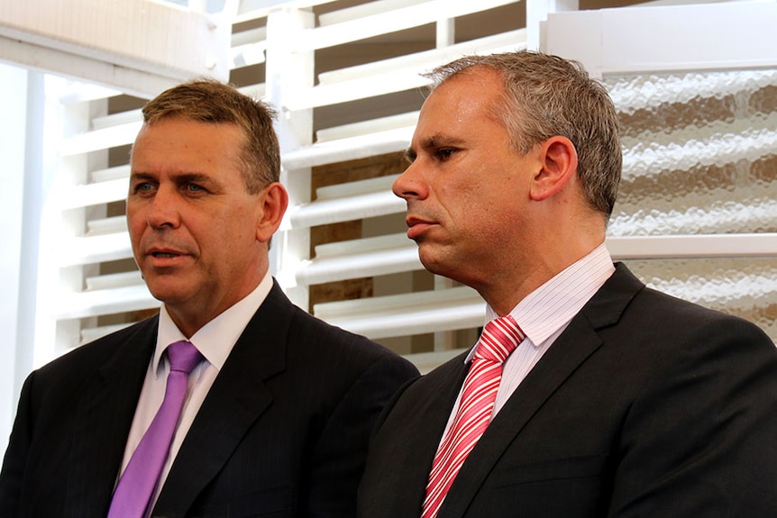 Photo of two men looking to left of shot outside Darwin's Government House