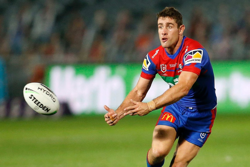 Andrew McCullough passes the ball during an NRL game with the Newcastle Knights.