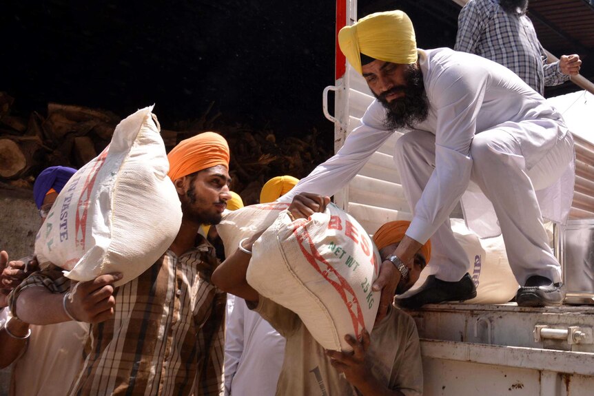 Indian volunteers load relief materials onto a truck to be taken to Nepal after the earthquake