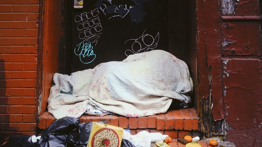 A homeless person sleeping rough on the streets