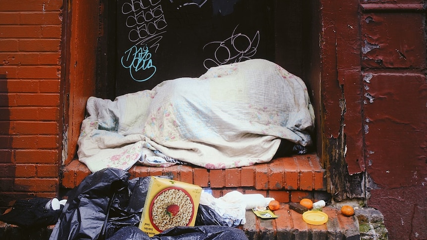 A homeless person sleeping rough on the streets