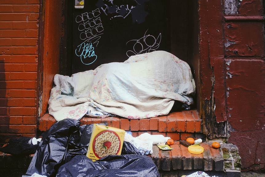 Бездомник спи грубо на улицата