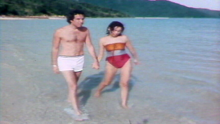 People walk on the beach of South Molle Island in a TV still from 1986.