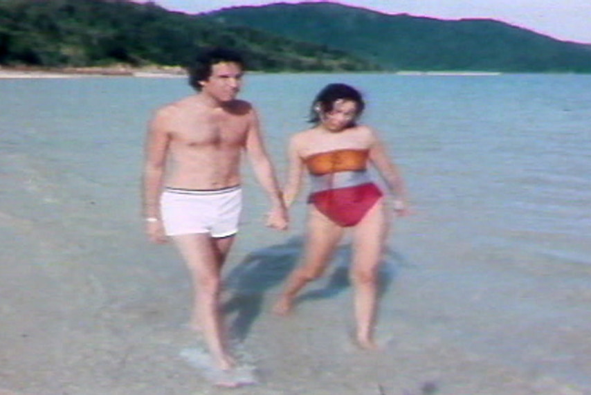 People walk on the beach of South Molle Island in a TV still from 1986.