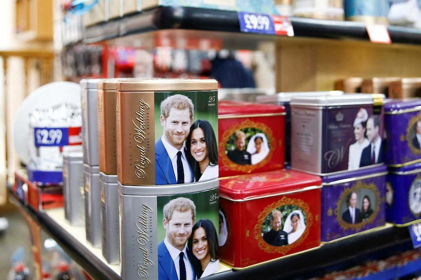 Colourful products with photos of Prince Harry and Meghan Markle sit on gift shop shelves with price tags.