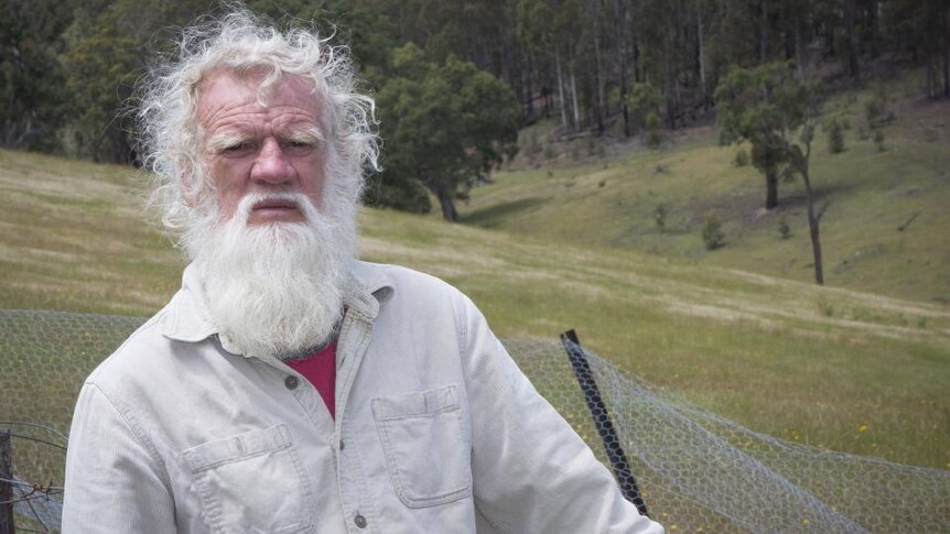 Bruce Pascoe stands on hillside