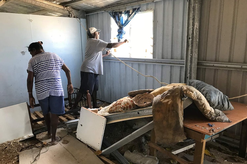 Basana and Banasi Gimini try to clean up some of the damage to their Yam Island home.