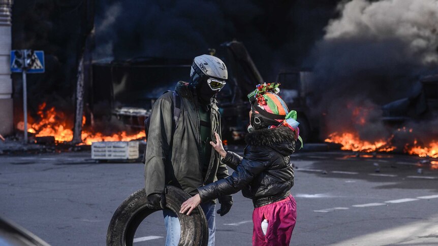 Rioters talk near a barricade in violent clashes with authorities in Kiev, Ukraine.