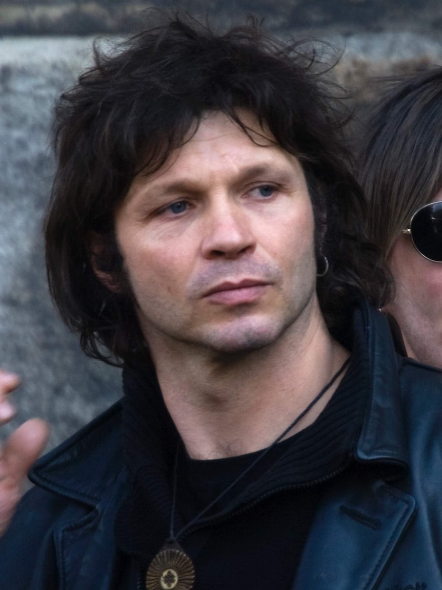 French singer Bertrand Cantat leaves after funeral services.