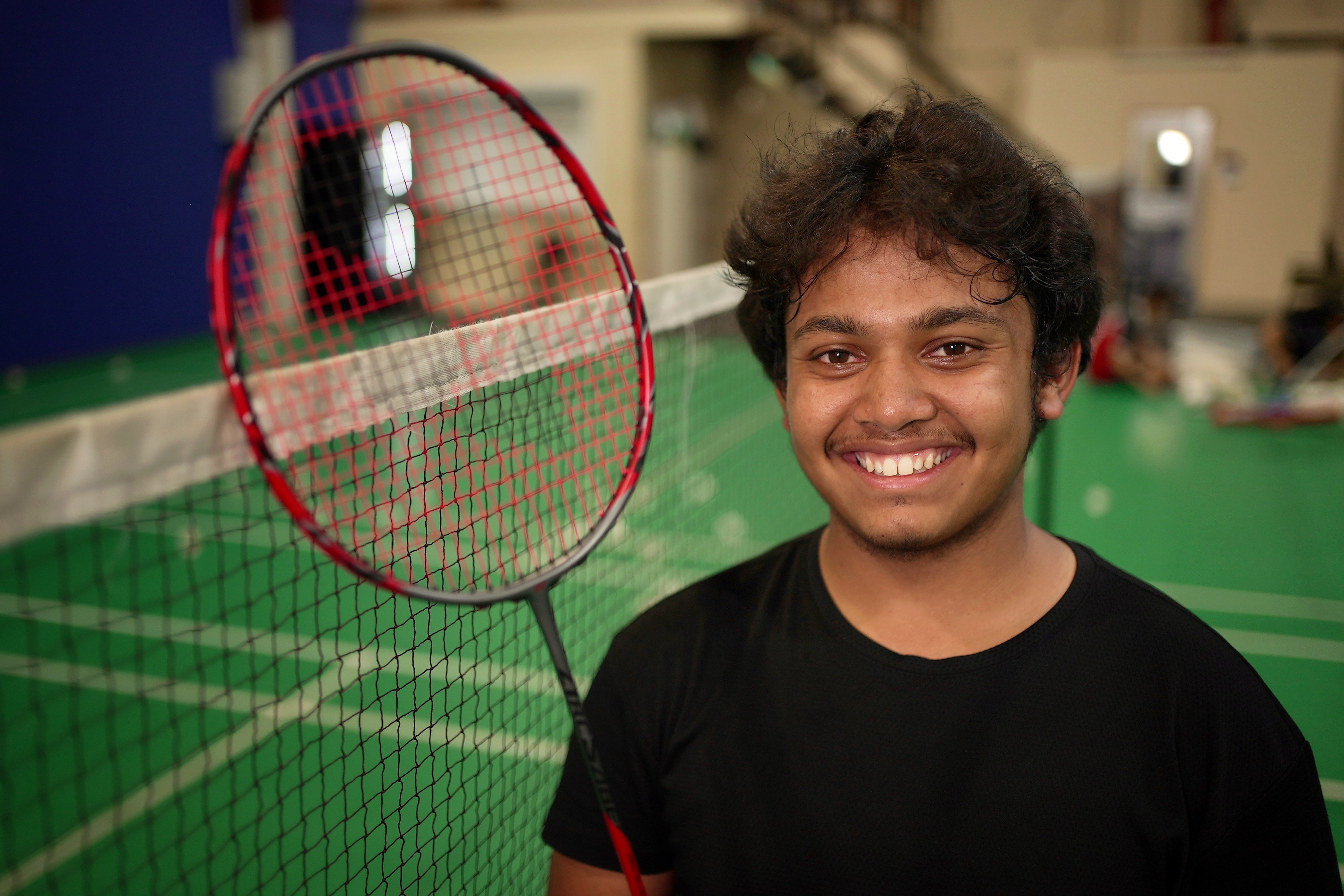 Rezwan Mohammed holding up his racquet.