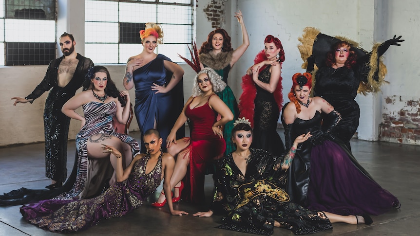 Group photo of the finalists dressed glamorously in a warehouse setting. 