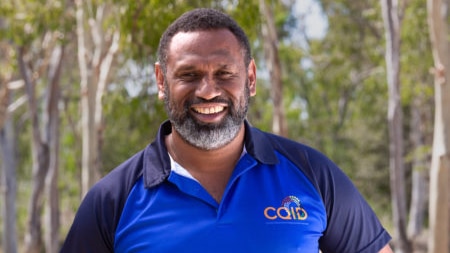 Portrait of man smiling with trees behind him