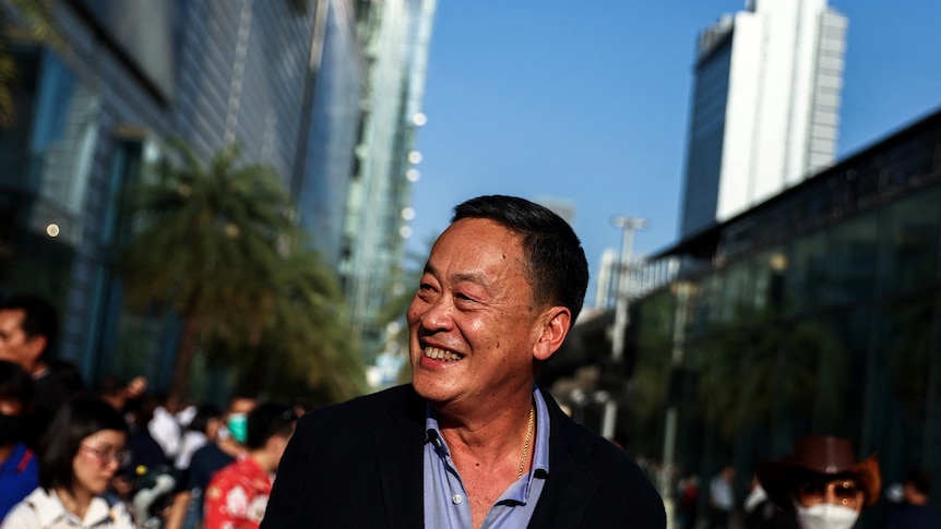 A Thai man smiling in a crowd 