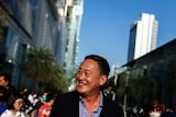 A Thai man smiling in a crowd 