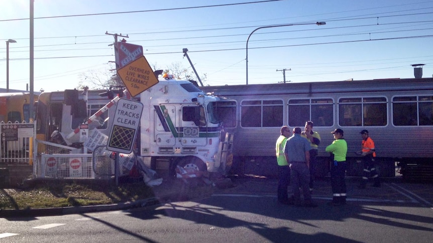 Emergency services tend to a passenger train after it crashed into a semi-trailer at Banyo.