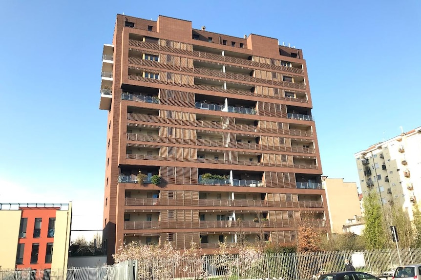 An apartment building rises above the street.