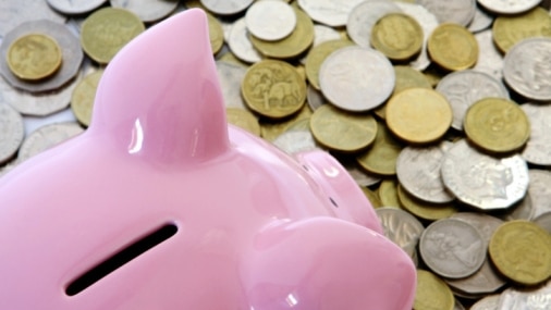 A piggy bank sits on a pile of Australian coins. (Thinkstock: iStockphoto)