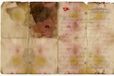 A letter is written in cursive handwriting on a stained and damaged piece of paper with a Titanic letterhead.