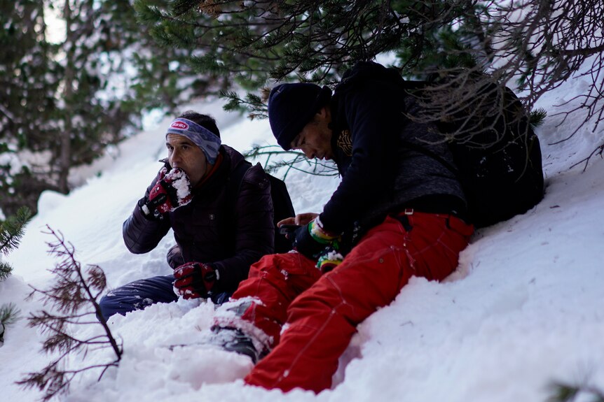 A migrant eats snow during a trek across the French-Italian Alps 