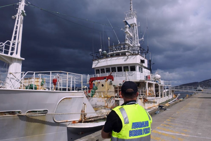 Officer in front of suspected Chinese drug ship in Hobart