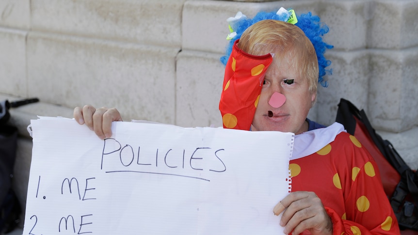 A pro 'remain' protester is dressed as a clown with a picture of  Boris Johnson's face imposed over his