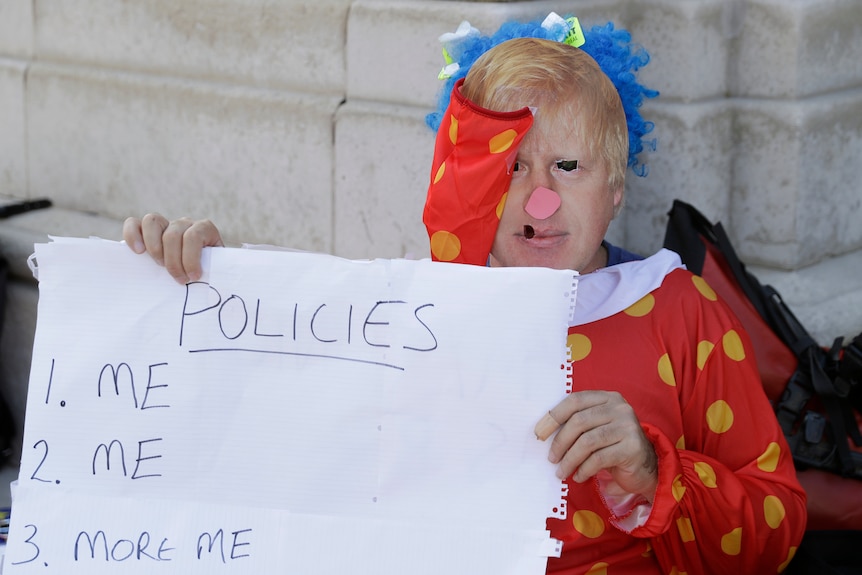 A pro 'remain' protester is dressed as a clown with a picture of  Boris Johnson's face imposed over his