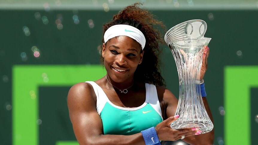 Record triumph ... Serena Williams poses for photographers with the winners trophy