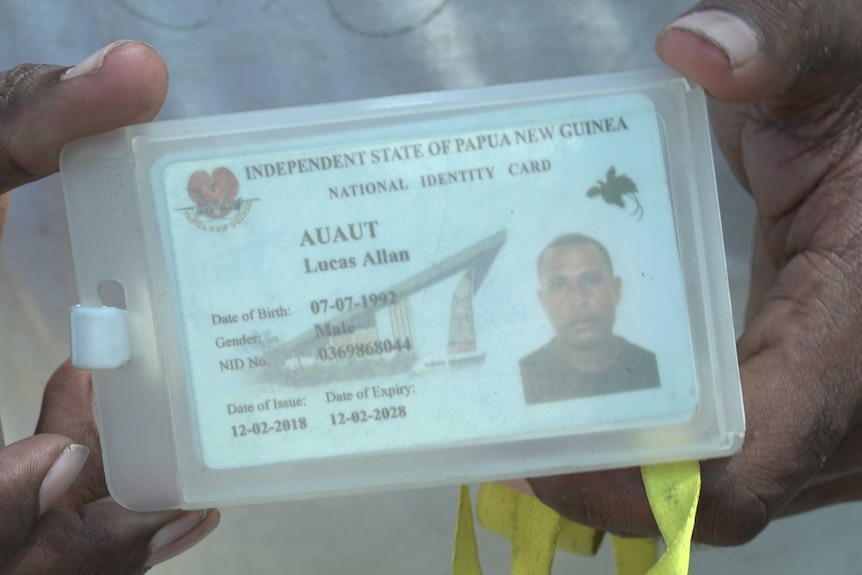 A man holds an ID card