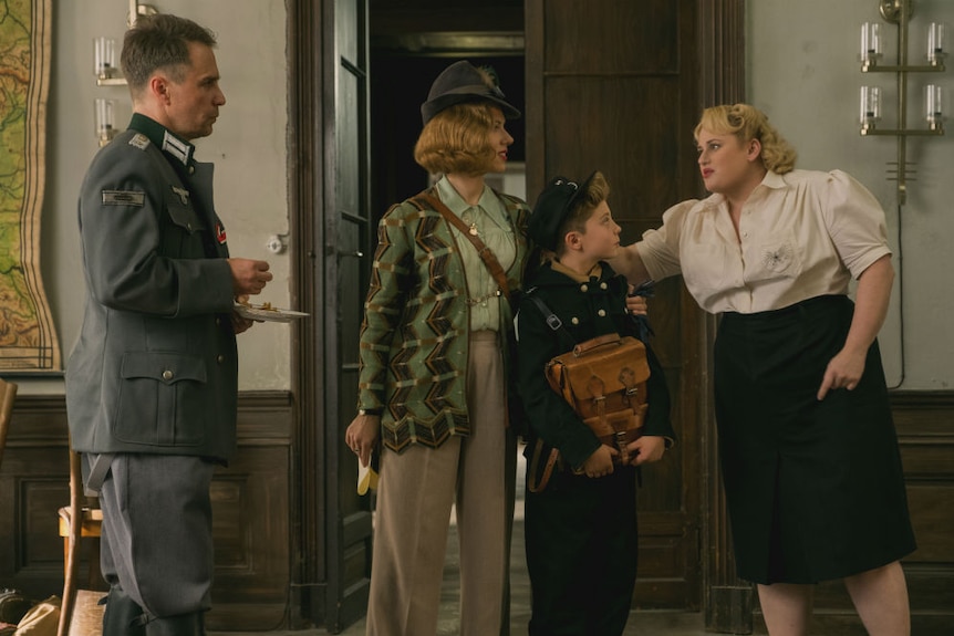 A man, two women, and a boy all dressed in German clothing of the 1940s.