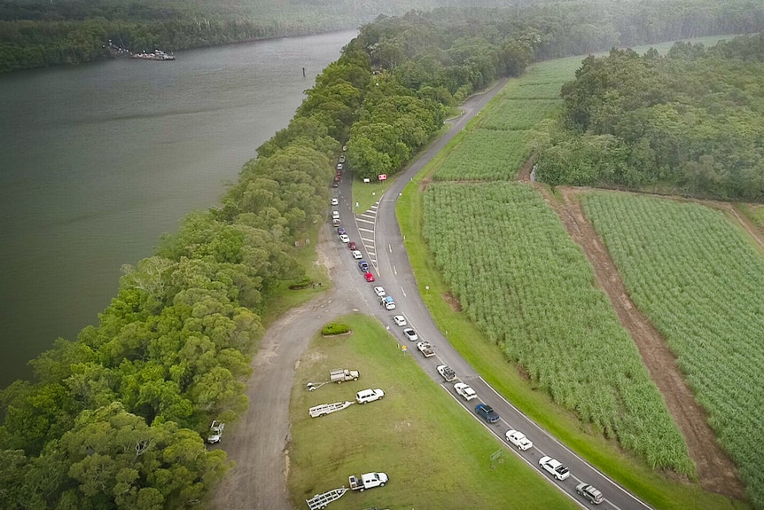 Imagen aérea de autos haciendo fila cerca del río