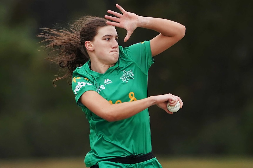 Annabel Sutherland, wearing a green Melbourne Stars kit, is in the midst of her bowling action.