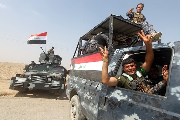 Iraqi security forces and paramilitaries ride in armoured vehicles