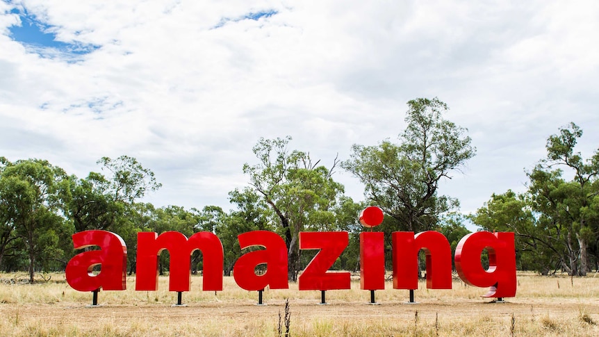 Red letters spelling the word Amazing form a sculpture in a paddock