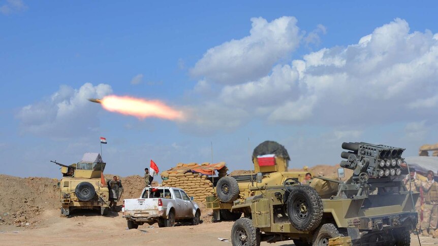 Iraqi government forces and allied militias fire weaponry