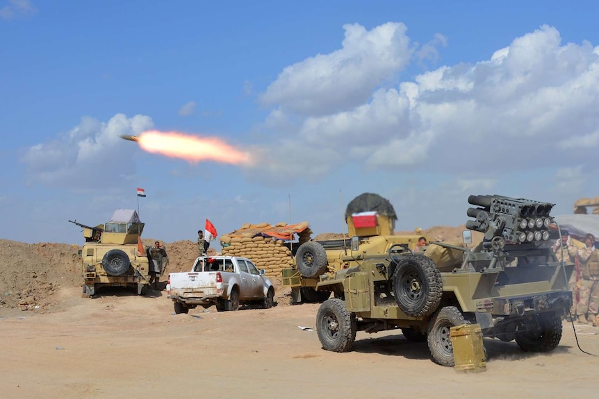 Iraqi government forces and allied militias fire weaponry