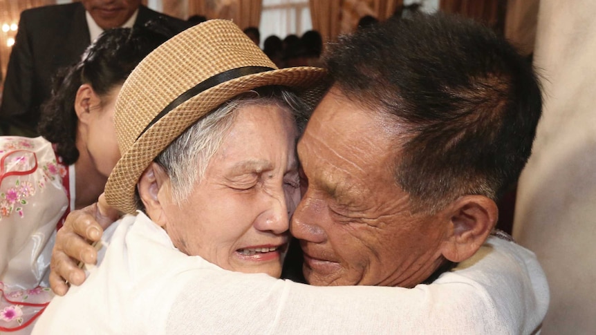 An emotional lady and a man embrace.