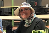 A smiling woman wearing a bonnet and glasses.