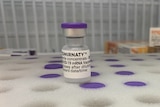 A close up of a COVID-19 vaccine vial