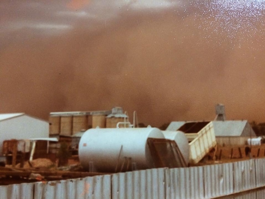 Dust storm at Peak Hill with grain silos in background.