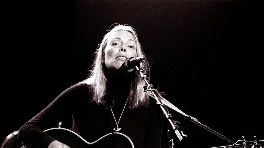Joni Mitchell performing on acoustic guitar