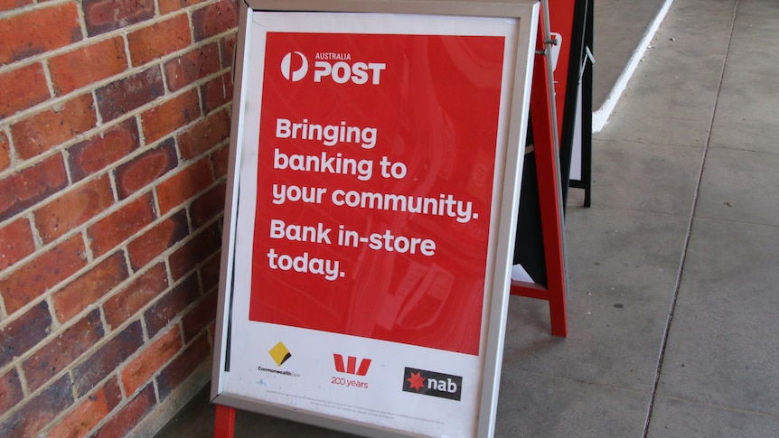 A red sign bearing the logos of three major banks, and not ANZ, advertises the Bank at Post service