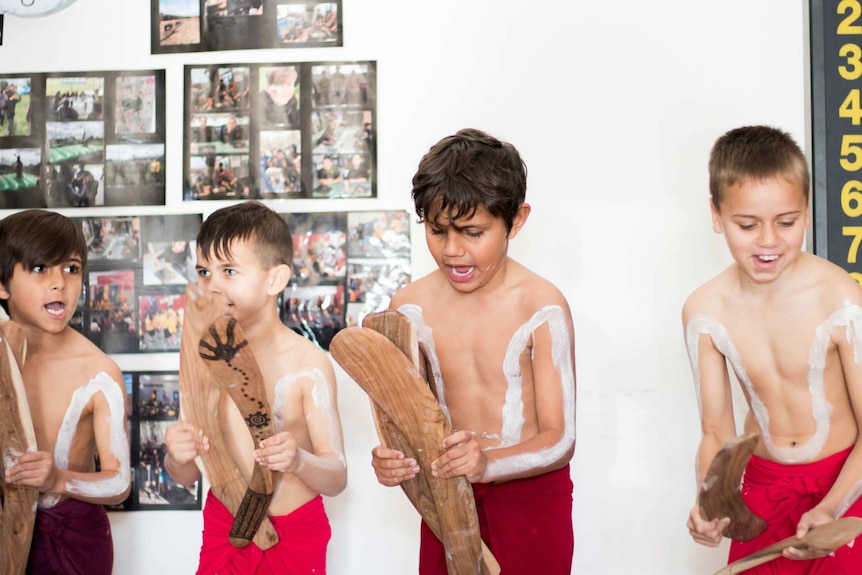 Four young Indigenous boys perform a traditional dance