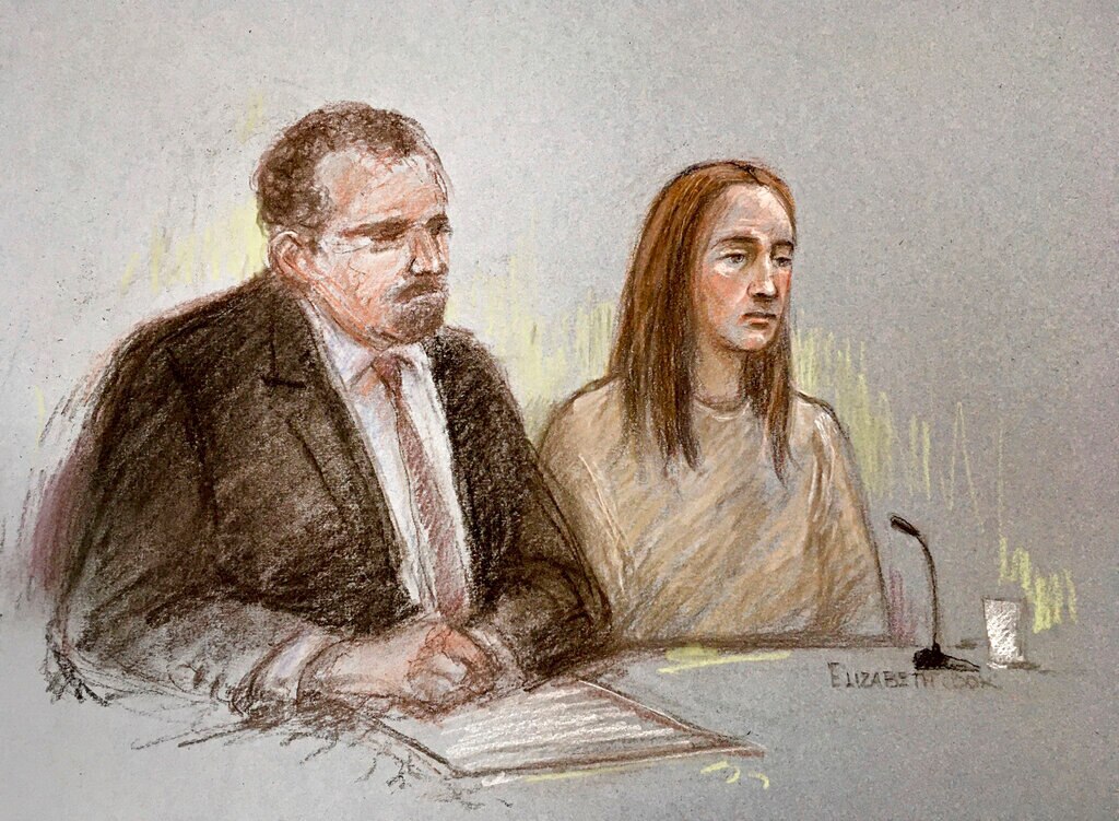 You view a court sketch of a woman with brown hair in beige prison clothing sitting next to a lawyer in a black suit.