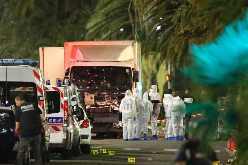 Police stand next to a truck that ran into a crowd celebrating Bastille Day.