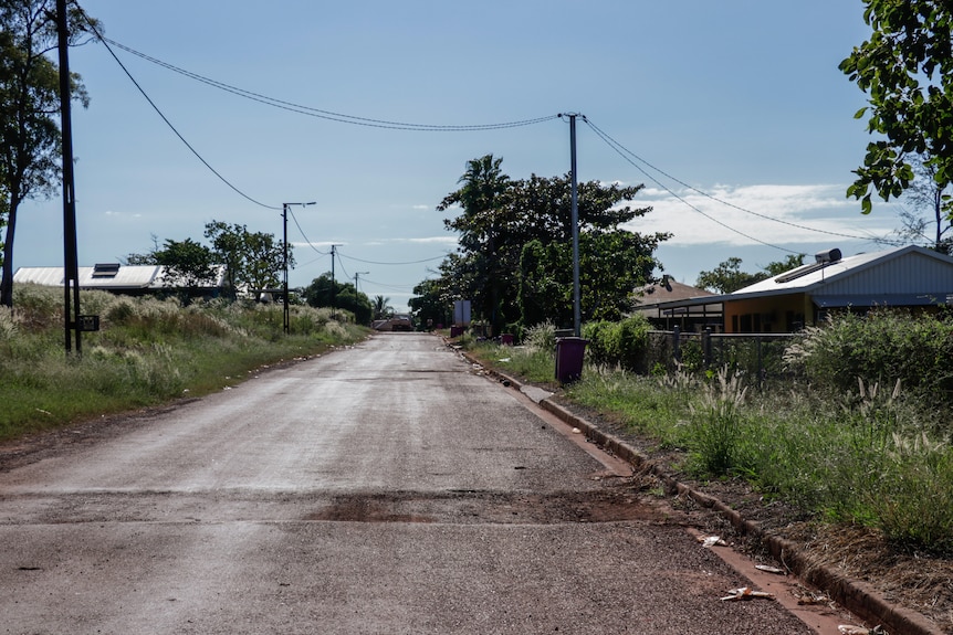 A street with houses. The street itself is rough.