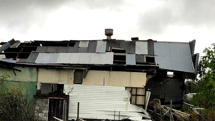 A badly damaged building, missing parts of its tin roof and wall, after being hit by a hailstorm