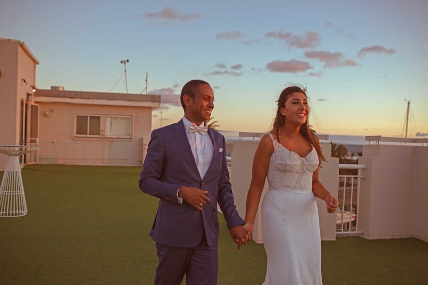 Eleni and Chris make their way to the rooftop for official wedding photos at sunset.