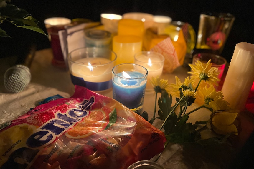 A bag of mints, candles and flowers on a table