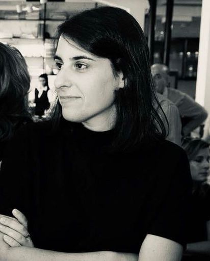 Una imagen en blanco y negro de una mujer de cabello oscuro con un top oscuro.